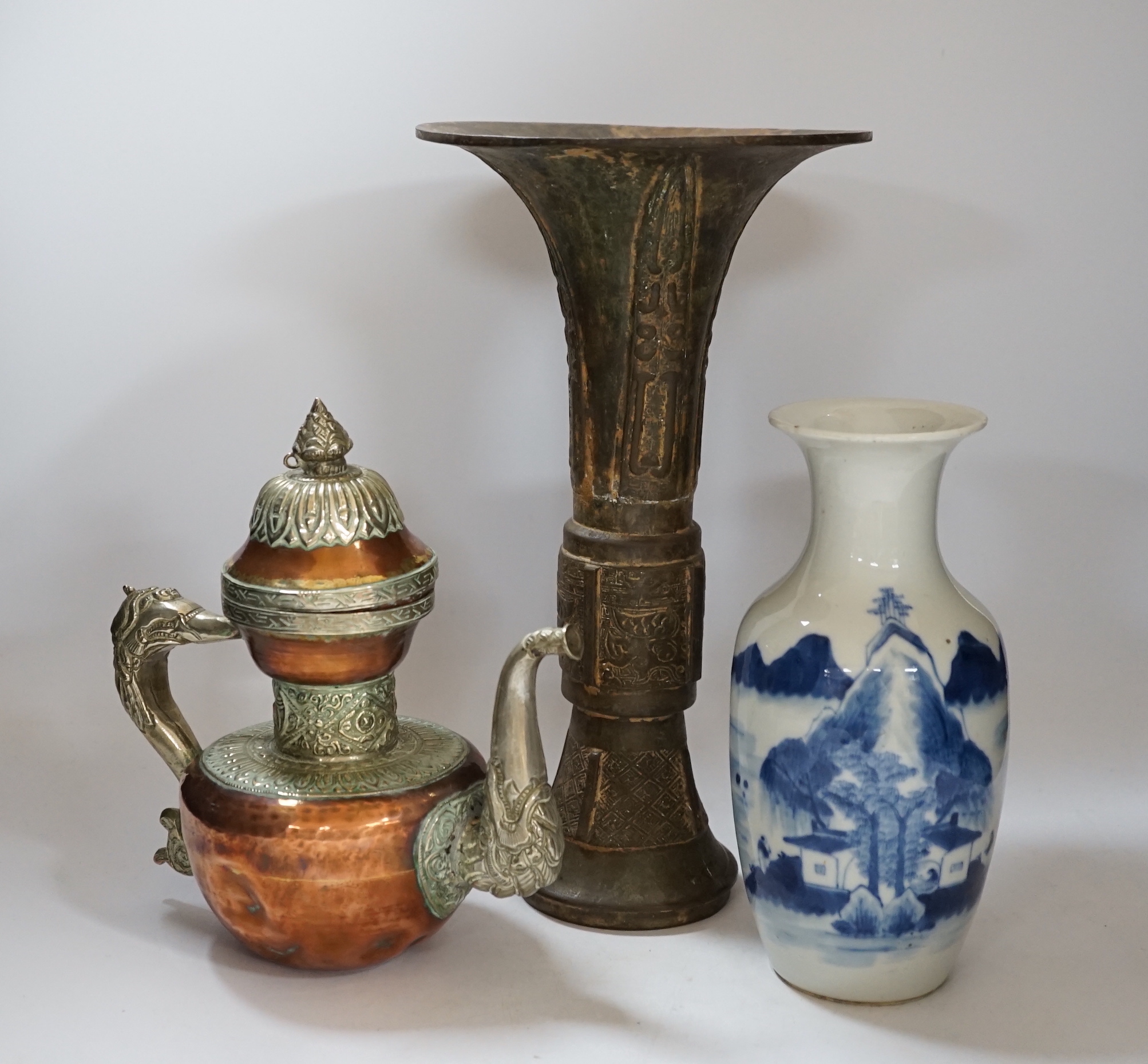 A Chinese bronze gu vase, a 19th century Chinese blue and white vase and a Tibetan teapot, tallest 34cm